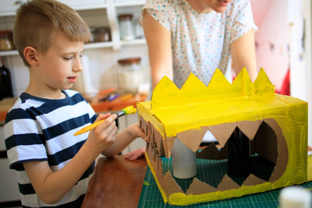 istock Boys painting a cardboard dinosaur costume 1226954782