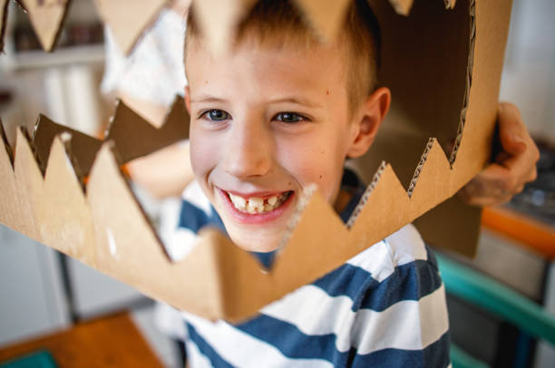 istock Smiling boy wearing a cardboard dinosaur costume 1226954930
