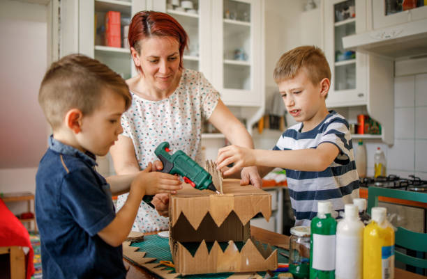 istock Mother helping her children to use hot gun 1226954964