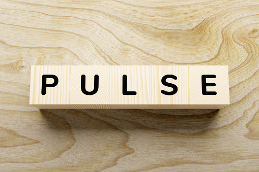 PULSE - words from wooden blocks with letters, feel worried and nervous stress concept, top view light background.