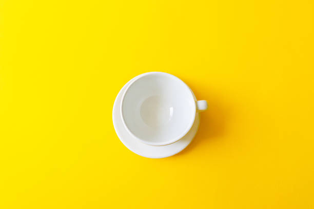 top view of an empty white ceramic cup on a yellow background. concept morning breakfast, drink coffee or tea. - coffee cup isolated cappuccino multi colored imagens e fotografias de stock