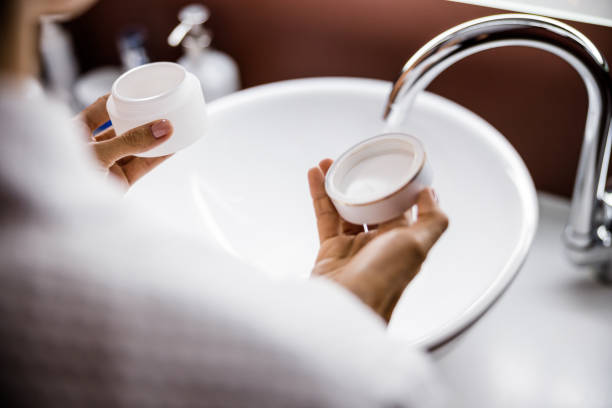 istock Woman using cosmetic cream in bathroom at home 1226955708