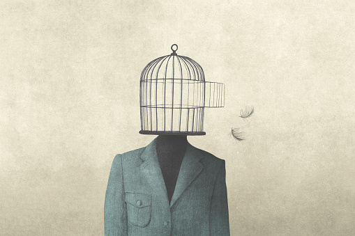 hombre con jaula de pájaros abierta sobre su cabeza, concepto de libertad surrealista photo