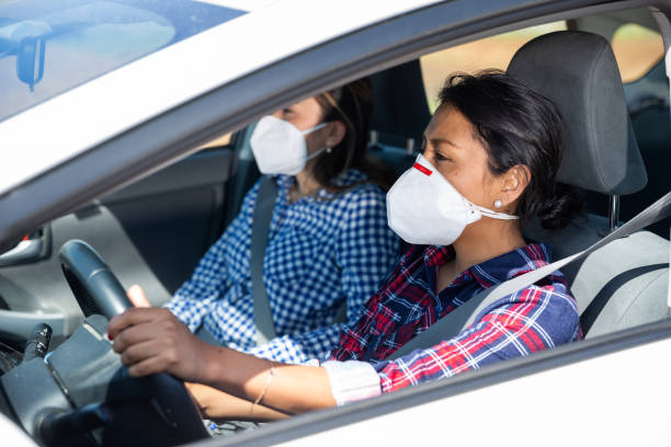 istock Women wearing personal protective equipment while driving a car 1226958324