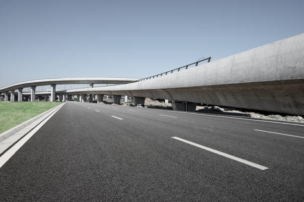 Clear blue sky and white clouds in the background, highway overpass curved approach bridge