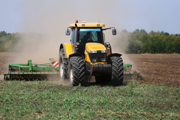 istock Tractor plows the field in the spring. Front view 1226960380