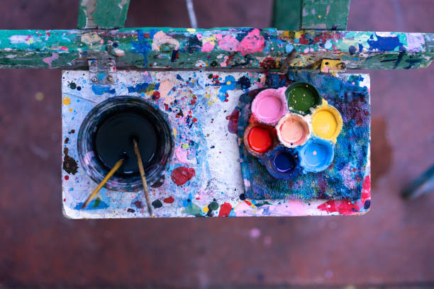 istock Colourful palette and paintbrushes on wooden table after use 1226960773