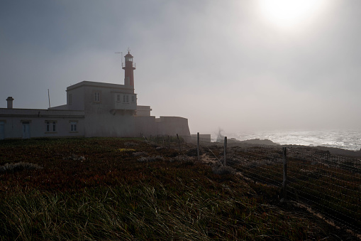Europe, Portugal, Caiscas. Silhouette of a lighthouse in the fog on the Portuguese Atlantic coast.