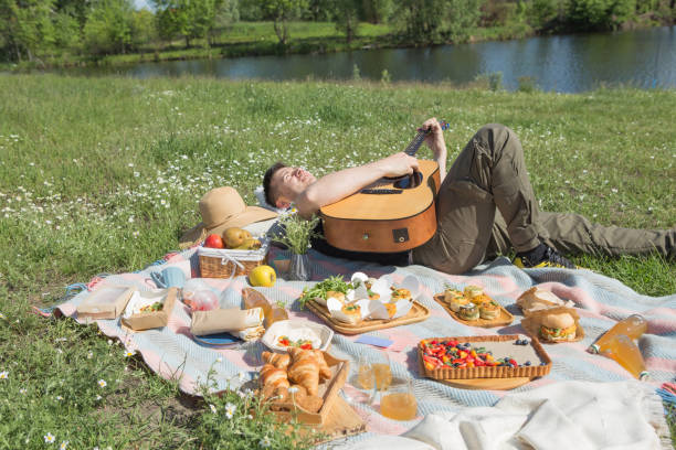 istock Man Lying on Back Playing Guitar at Picnic 1226968671
