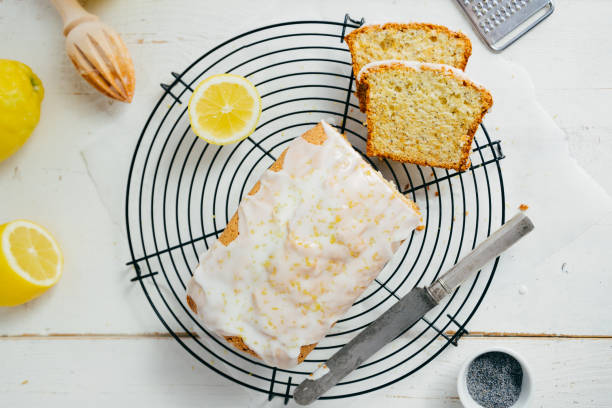 pão de bolo de limão envidraçado com semente de papoula no rack de resfriamento - bolo ingles - fotografias e filmes do acervo