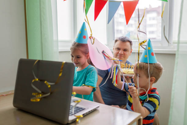 Happy father with two sibling celebrating birthday via internet in quarantine time, self-isolation Happy family with two sibling celebrating birthday via internet in quarantine time, self-isolation and family values, online birthday party, selective focus on girl virtual birthday celebration stock pictures, royalty-free photos & images