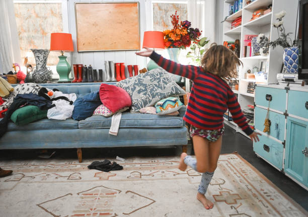 Wild kid in a messy domestic home, chaos and childhood Young child runs around wild and dressed silly in a messy real domestic family home, real life cluttered photos stock pictures, royalty-free photos & images