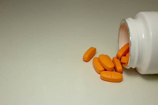istock Pills spread over a white table, next to the open bottle 1226974297