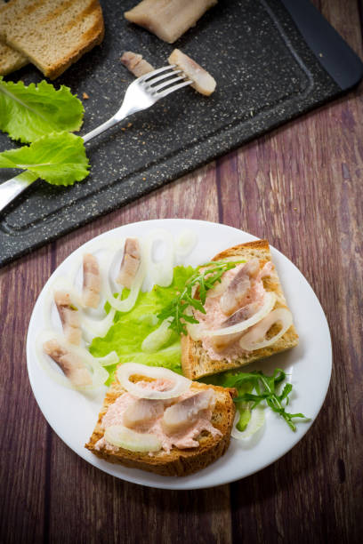 istock sandwich with salad, herring and herbs with onions in a plate 1226976000