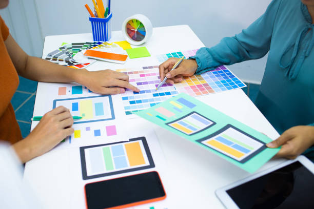 istock close up hand Team designers are testing the mobile phone screen to suit their usage.UX UI and Programming development concept 1226976157