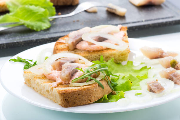 istock sandwich with salad, herring and herbs with onions in a plate 1226976254