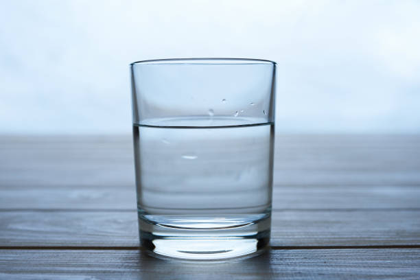 istock Glass half full on a wooden table 1226977337