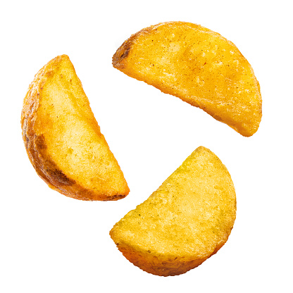 Flying tasty fried potato wedges, isolated on white