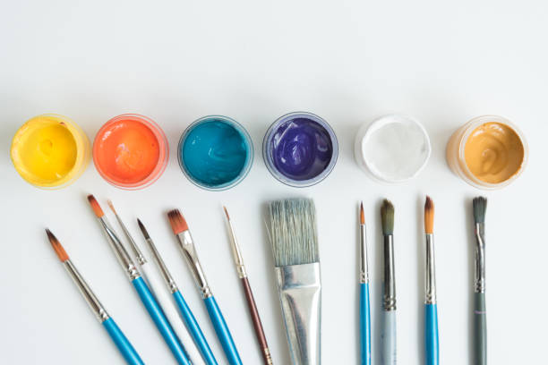 istock Open jars with gouache and paint brushes of different sizes. The view from the top. Background, texture. The concept of space for creativity and choice. 1226980292