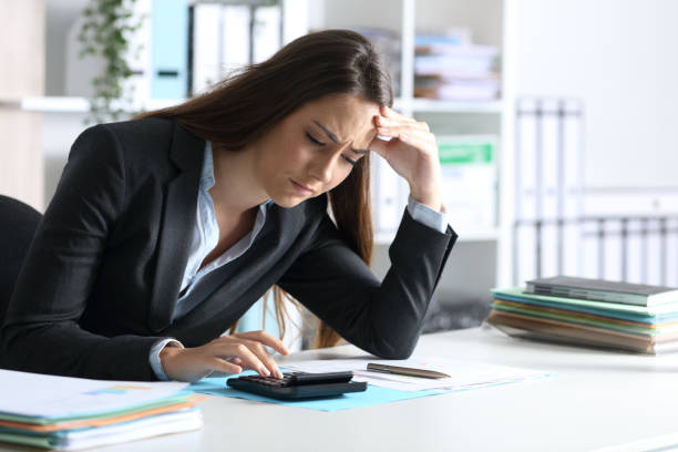 Worried bookkeeper calculating on calculator at office