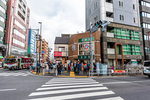 Tokyo, Japan - April 1, 2019: Shinjuku street sidewalk with people in evening waiting in line queue for bubble tapioca boba tea in Kitashinjuku residential neighborhood