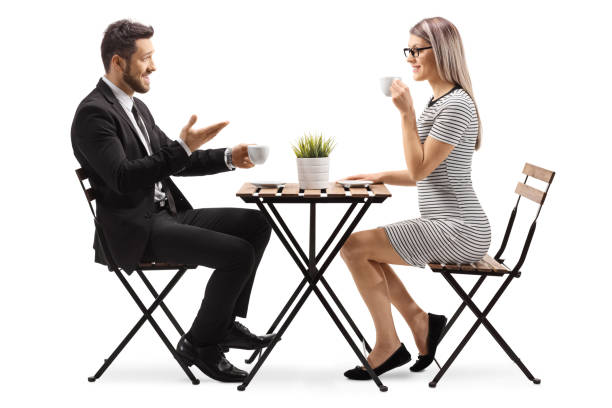 카페에 앉아 커피를 마시는 여성과 이야기하는 사업가 - table restaurant chair people 뉴스 사진 이미지