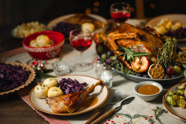 cena de navidad servida en una mesa de comedor - goose roasted goose meat spit roasted fotografías e imágenes de stock