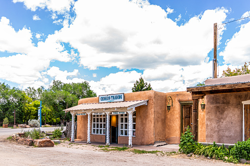 Ranchos de Taos, USA - June 19, 2019: Famous St Francic Plaza in New Mexico with Taos trading post store selling souvenirs chimayo sign