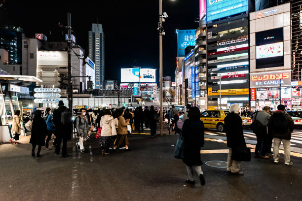 Famous crossing billboard advertisement lights and people by station at evening night in Tokyo Shibuya, Japan - April 1, 2019: Famous crossing in downtown city with neon billboard advertisement lights and people by station at evening night in Tokyo clarion angelfish photos stock pictures, royalty-free photos & images