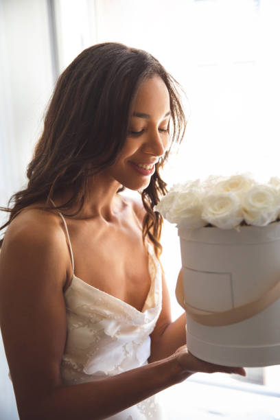 femme posant dans une robe blanche par sa fenêtre de maison - wedding black and white weddings rose photos et images de collection