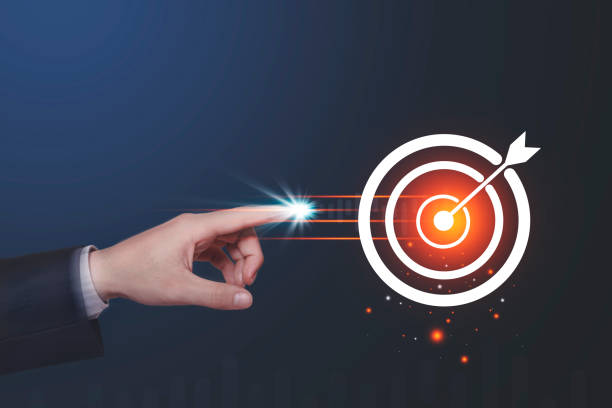 istock Human hand touching glowing point at target circle with light effects on dark blue background. Business goal setting concepts 1226987129