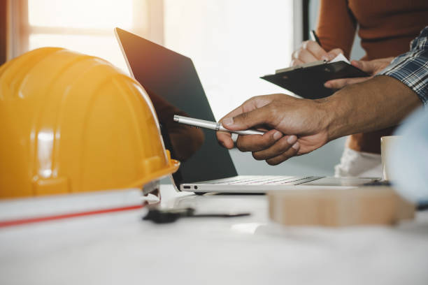 istock hands of group engineer and architect working on laptop computer and blueprint on workplace desk in meeting room project at construction site office, contractor, engineering and construction concept 1226988864