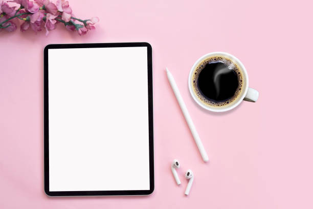 istock Modern tablet, white wireless headphones with coffee on a pink background. 1226988902