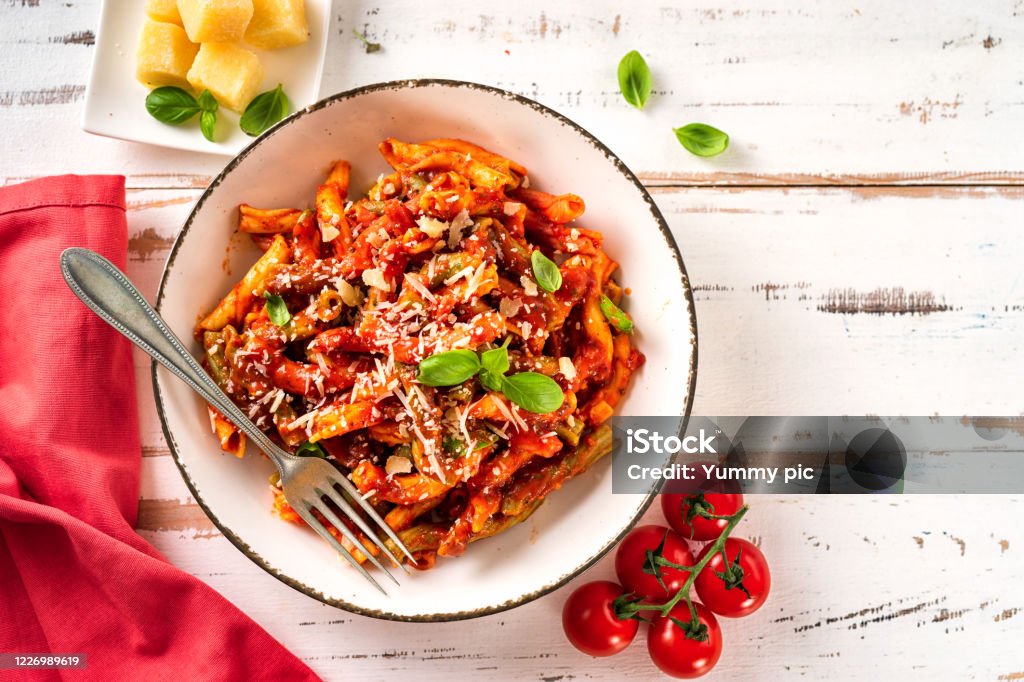 Top view of plate with colorful intalian pasta freshly cooked Top view of plate with colorful italian passta on white wooden table. Close up Above Stock Photo