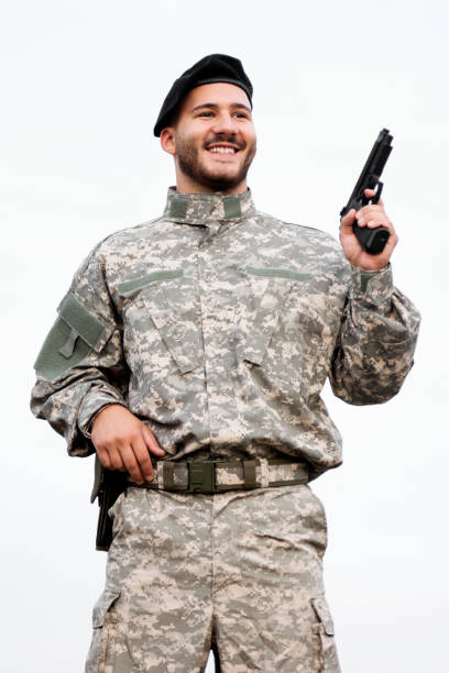 istock smiling soldier with pistol 1226991198