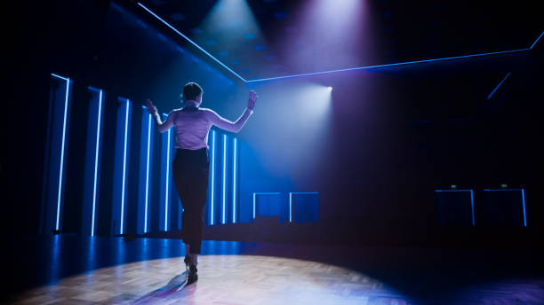 istock Famous Female Entertainer Gets on the Stage, Greets Audience, Starts Performance. Software Company Founder, Tech Marketing Guru Making a Pitch, Speaker Giving Talk. Cinematographic Shot 1226991362