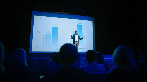 istock Startup Conference Stage: Speaker Presents New Product, Talks about Performance, Neural Networks, Artificial Intelligence, Big Data and Machine Learning. Live Event with Large Audience 1226991492
