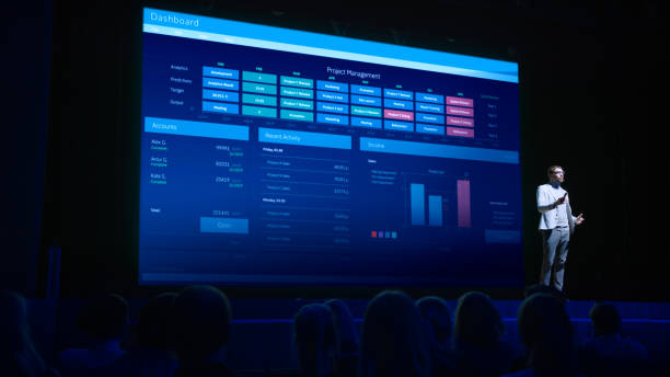 istock Business Forum Economics Conference Stage: Professional Speaker Concludes His Report with a Speech and Showing Infographics, Statistics on the Big Screen. 1226991505