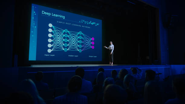 istock Computer Science Startup Conference: On Stage Speaker Does Presentation of New Product, Talks about Deep Learning, Shows New AI, Big Data and Machine Learning App on Big Screen. Live Event 1226991511