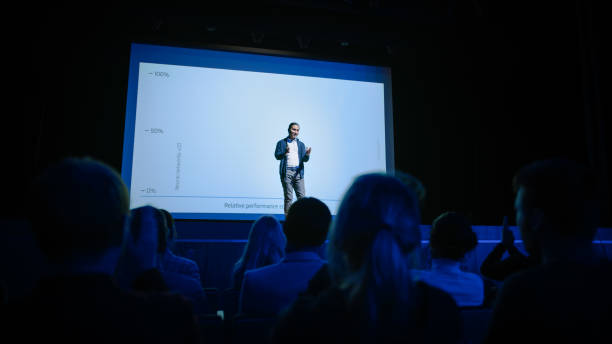 istock Conference Stage: Speaker Presents New Product, Talks about Performance, Neural Networks, Artificial Intelligence, Big Data and Machine Learning. Live Business Event with Large Audience 1226991611