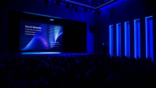 istock In Movie Theater Computer Science Startup Conference: Captivated Audience Watching Presentation of New Product, Talks about Neural Networks, Shows New AI, Big Data and Machine Learning App on Screen. 1226991655