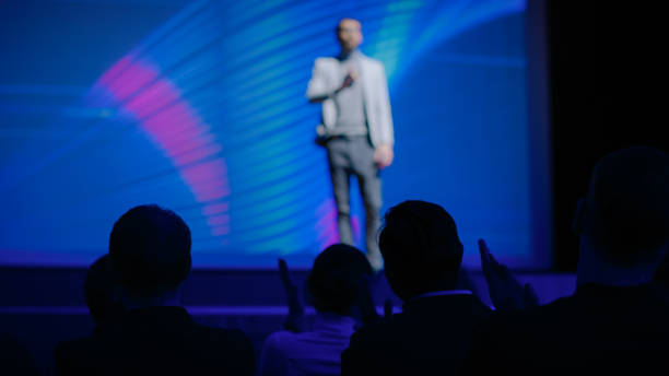 istock Tech Conference Auditorium Hall, Speaker Does Presentation New Product on Market, Talks about Performance Comparison. Focus on Applauding Audience. Device Release / Start-up Business Conference 1226991689