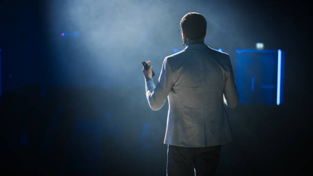 sul palco: speaker motivazionale di successo, che parla di felicità, sé, successo, empowerment, efficienza, salute e come essere più produttivi. grande sala conferenze con luce cinematografica - non urban scene foto e immagini stock