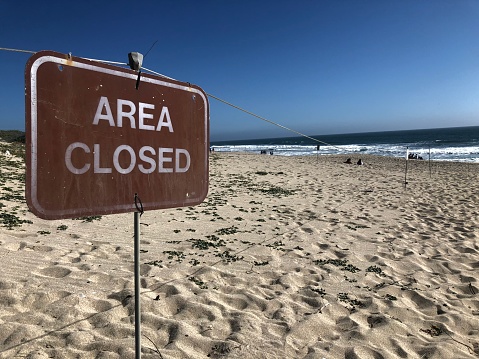 A sign reminds beachgoers to stay off the sand dunes.