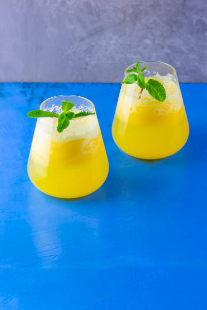 istock Pineapple cocktail on a blue gray background. Cold pineapple cocktail with mint. Summer tropical cocktail. Healthy drink 1226994055