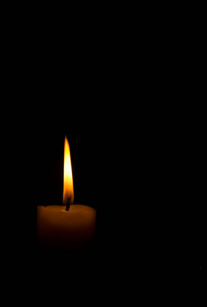 istock One blue candle flame burning in darkness. 1226994086