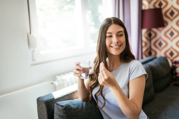 istock Cheerful young woman taking supplements and vitamins 1226994172