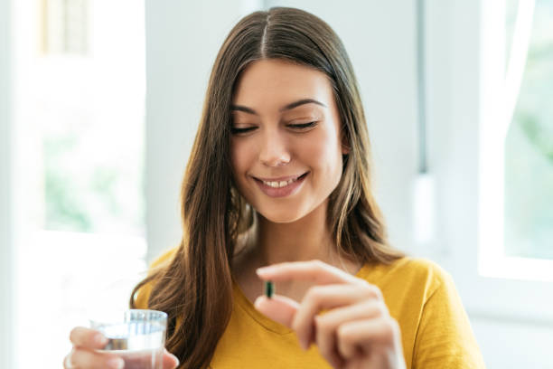 istock Healthy young woman taking herbal supplements 1226994243