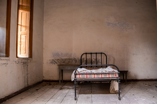 Una cama en una clínica de leprosos abandonada photo