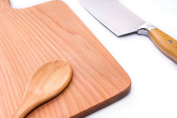 istock Natural wooden cutting board with a knife, kitchen tools. Tools for cutting products on a white background. 1226994497